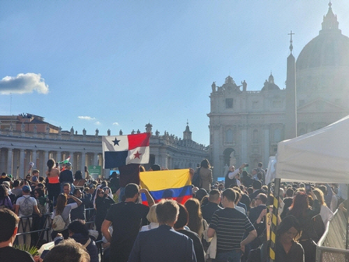 8일(현지시간) 바티칸 시스티나 성당에서 새 교황 탄생을 알리는 흰 연기가 피어오르자 성 베드로 광장을 가득 메운 인파가 각국 국기를 휘날리며 환호하고 있다. [바티칸=연합뉴스]